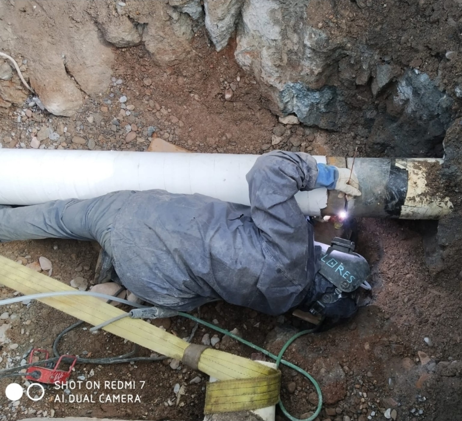 Soldador trabajando sobre tubería en obra